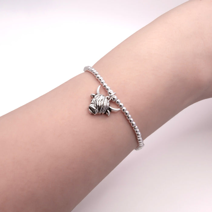 HC67 - Stretch Charm Bracelet with Silver Coloured Beads and Aileen Highland Cow Charm